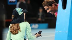 Tennis - Australian Open - Second Round - Melbourne Park, Melbourne, Australia - January 23, 2020. Spain’s Rafael Nadal passes a ball girl his head band after winning the match against Argentina’s Federico Delbonis. REUTERS/Hannah McKay