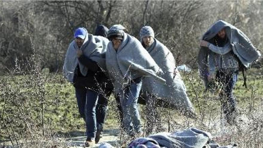 Immigrants abrigats amb mantes es desplacen cap al campament de refugiats de Miratovac.
