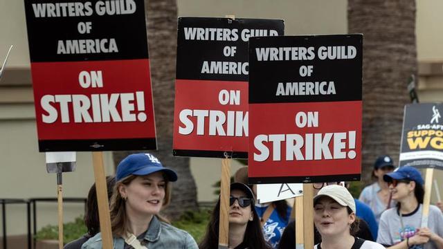 Los guionistas de Hollywood portan carteles en señal de protesta.