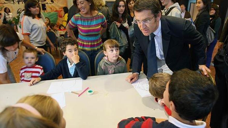 El presidente de la Xunta, Alberto Núñez Feijóo, conversa con varios niños en el congreso.  // Jorge Leal