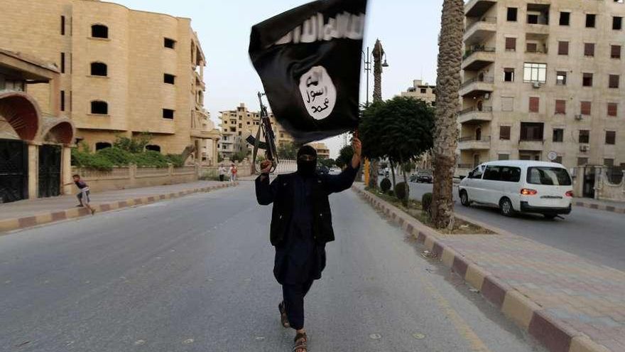 Un combatiente islamista porta una bandera en la ciudad de Raqqa.