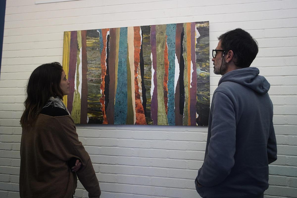 Dos visitants observen un quadre de l'exposició &quot;Retalls de natura&quot;.