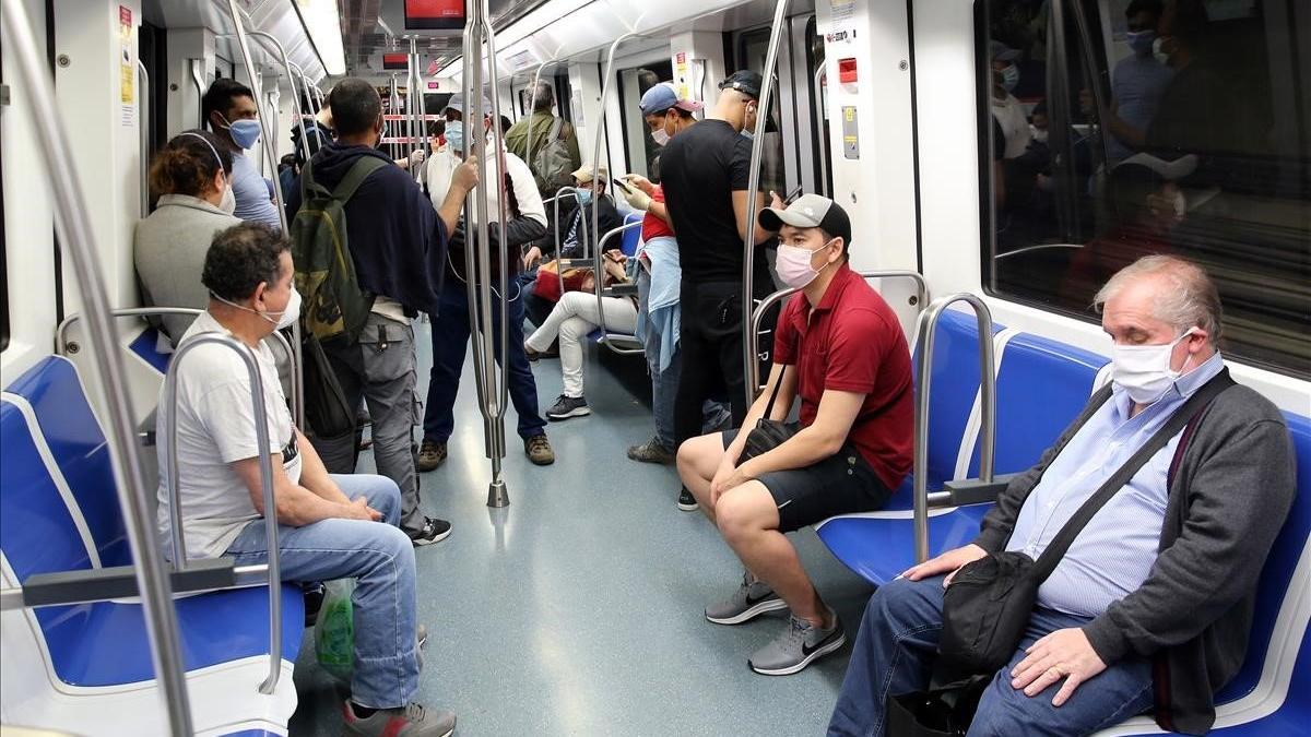 Pasajeros protegidos con mascarillas en un convoy de la línea 4 del metro de Barcelona