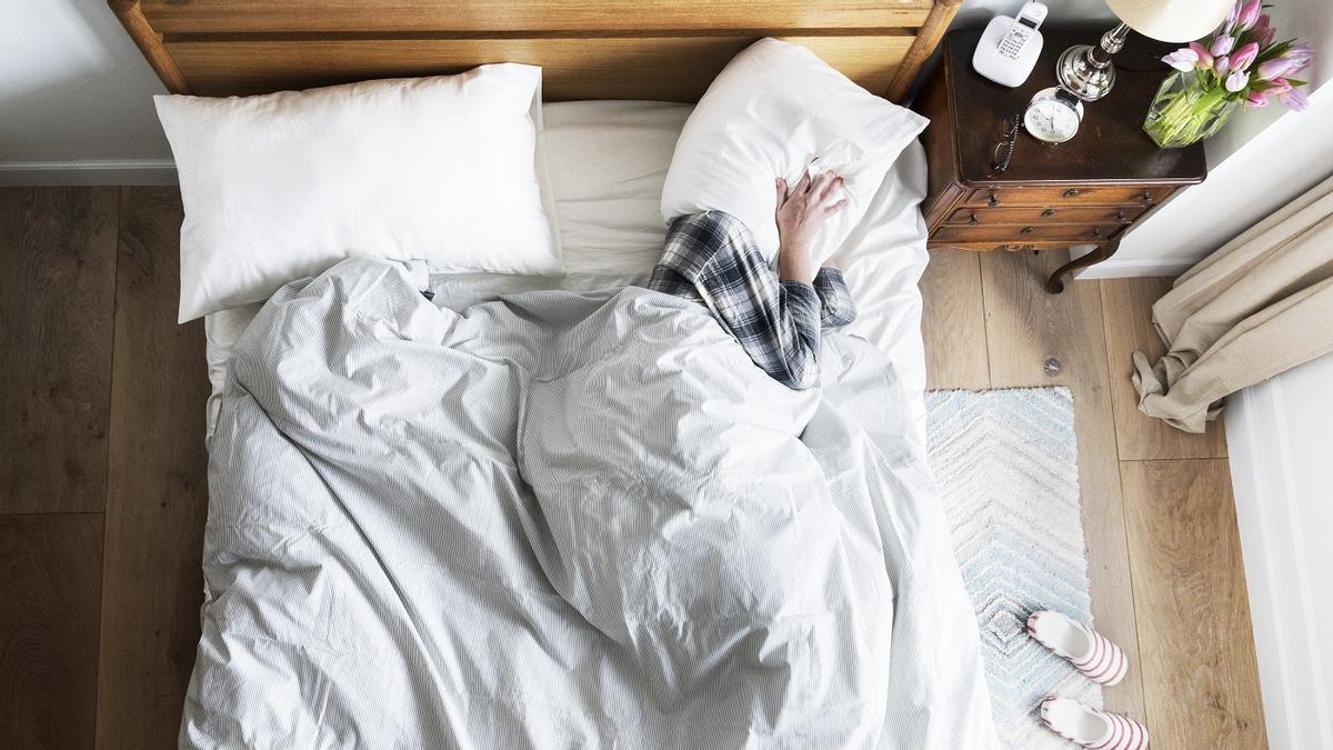 Una persona se tapa con la almohada para mitigar el ruido