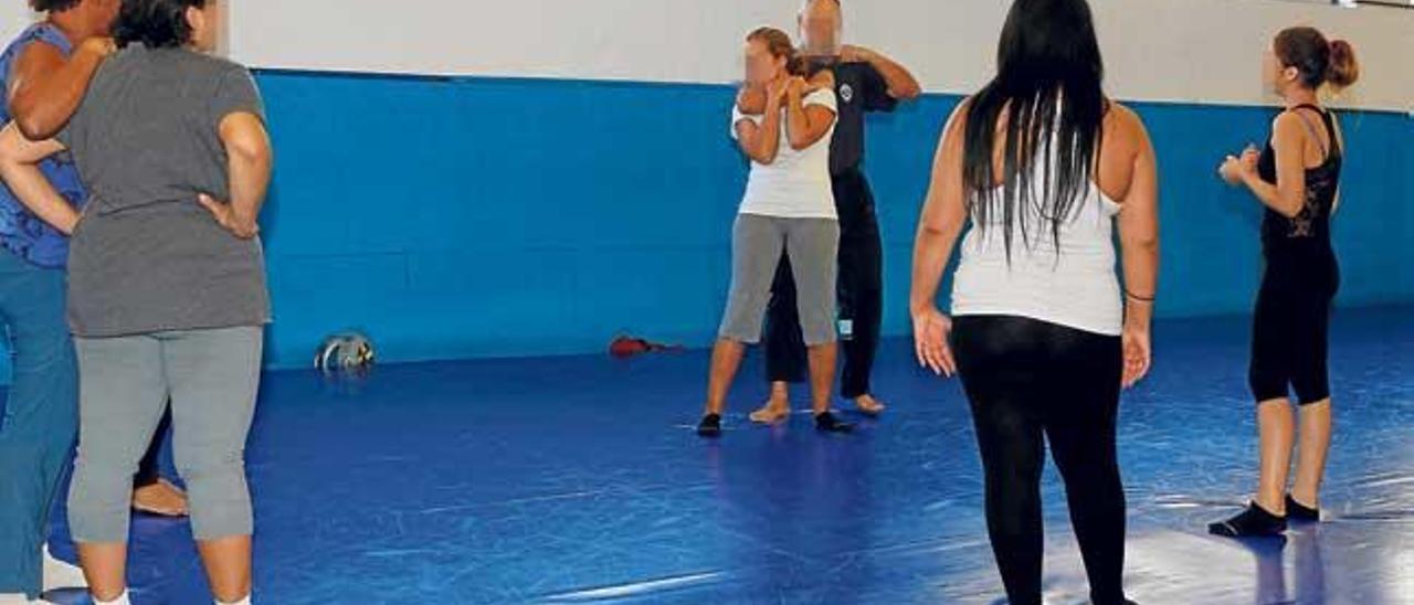 Un policía muestra técnicas de defensa personal a mujeres víctimas de malos tratos.