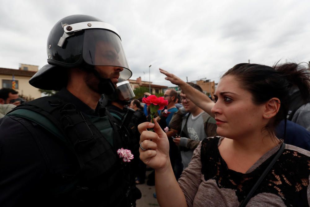 Una mujer ofrece una flor a un agente de la Guardia Civil.