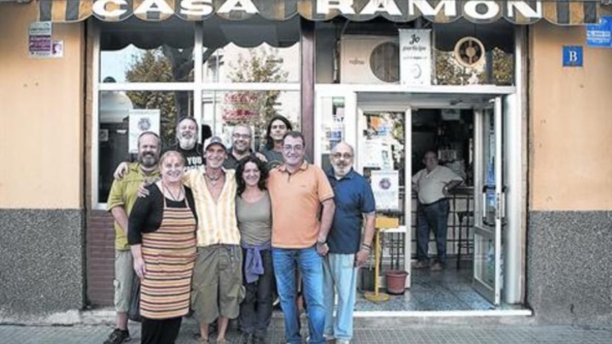 Un grupo de vecinos de Sant Cosme posa con Manu Chao (con gorra) frente al bar Casa Ramon, uno de los lugares míticos del barrio, el miércoles.