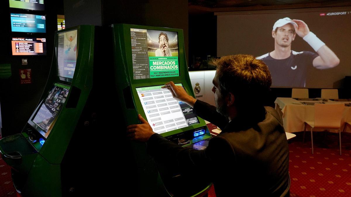 Un hombre juega a una máquina tragaperras antes del cierre de los salones de juego por la pandemia.