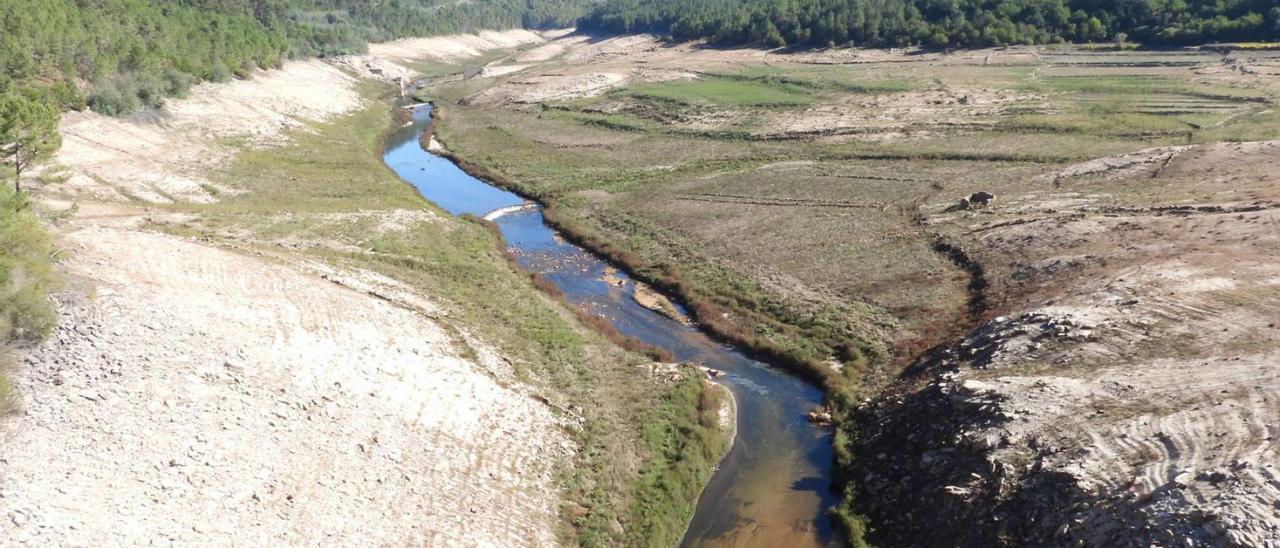 El río Limia, en Lobios, sin apenas caudal, y bañistas en la orilla del Miño, en Ourense. |   // FERNANDO CASANOVA/IÑAKI OSORIO