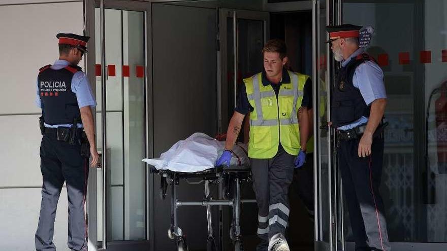 Momento en que el cadáver del argelino es sacado de la comisaría de Cornellá. // AFP