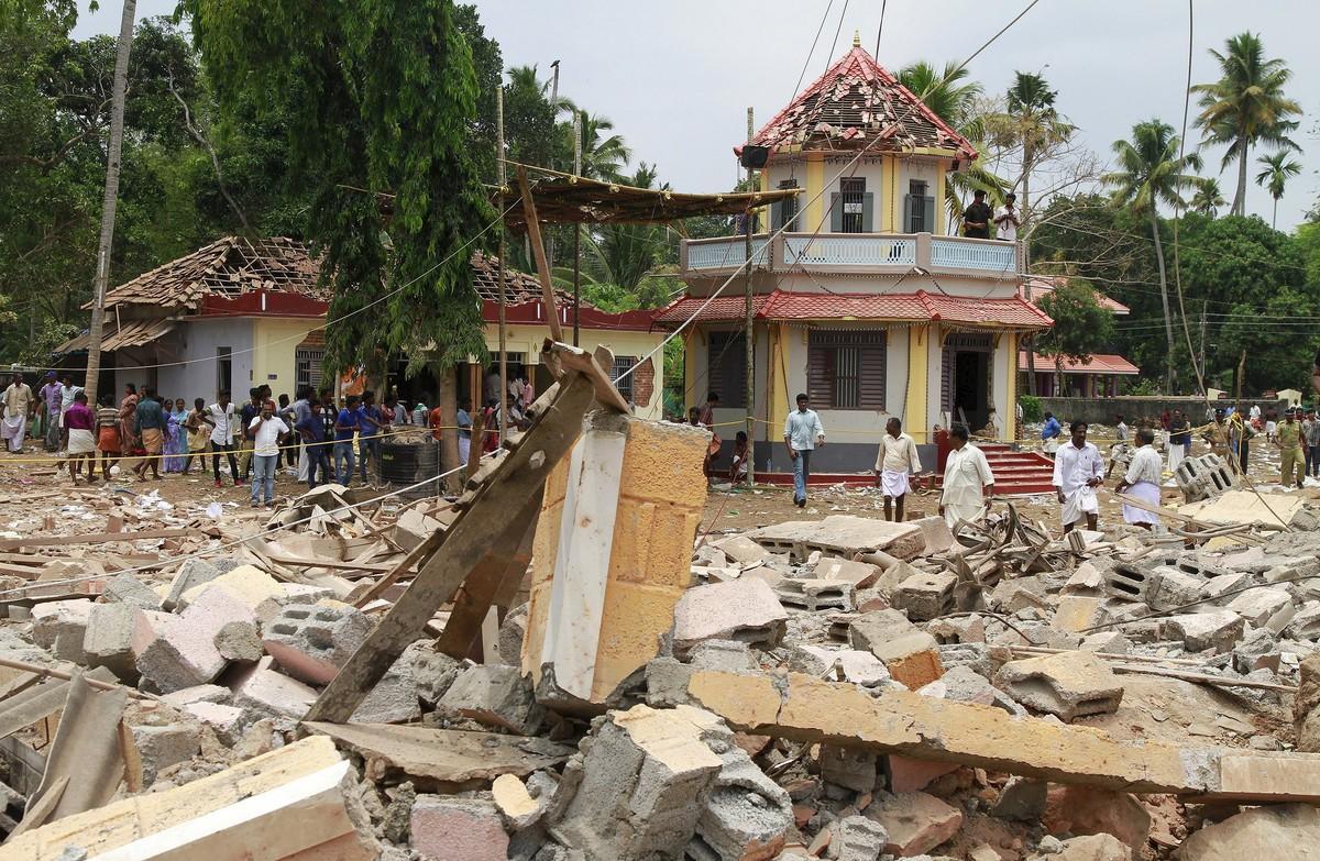 People stand next to debris after a broke out at a temple in Kollam in the southern state of Kerala, India, April 10, 2016. A huge fire swept through a temple in India’s southern Kerala state early on Sunday (April 10), killing nearly 80 people and injuring over 200 gathered for a fireworks display to mark the start of the local Hindu new year. REUTERS/Sivaram V