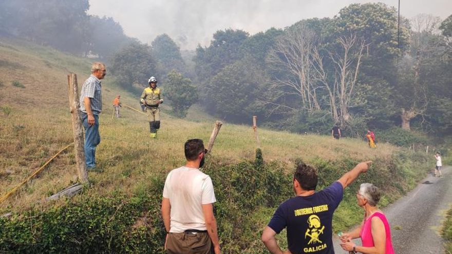 Los vecinos y vecinas de San Xoán de Río colaborando con las brigadas antes de que el fuego afectase a una población. | // F..C.