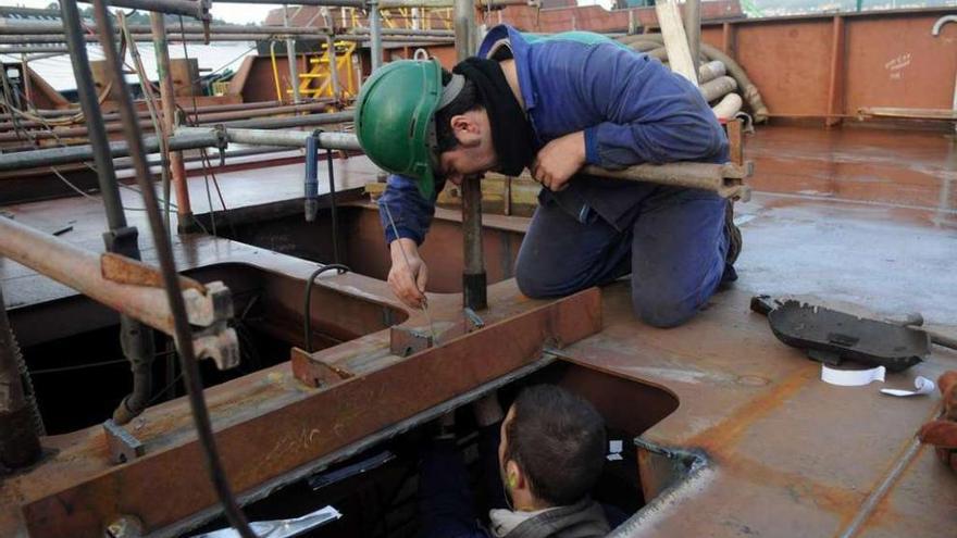 Dos operarios de un astillero gallego trabajan en la construcción de un buque.