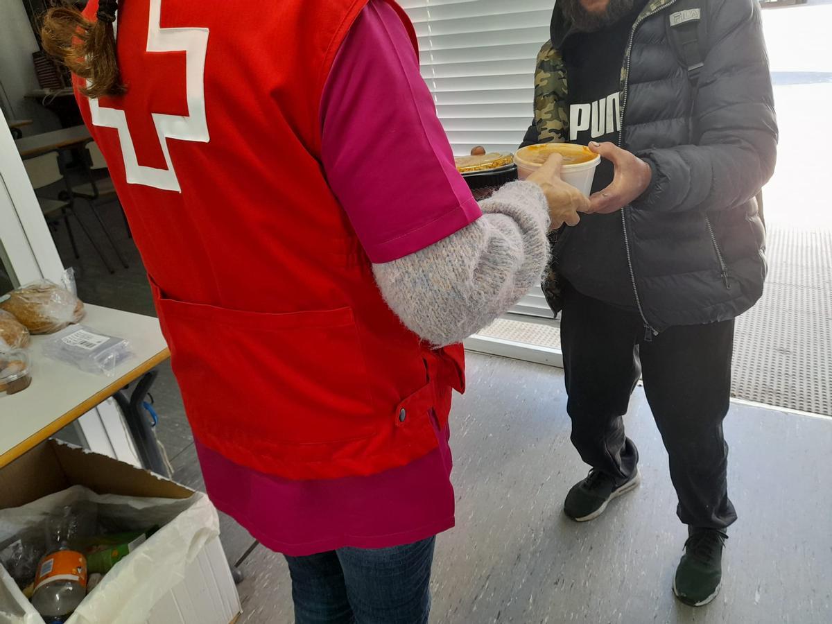 Una persona sin hogar recoge su menú este martes en el centro de intervención de Cruz Roja