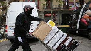 Un transportista descarga una botellas de vino en el Eixample, en abril de 2021