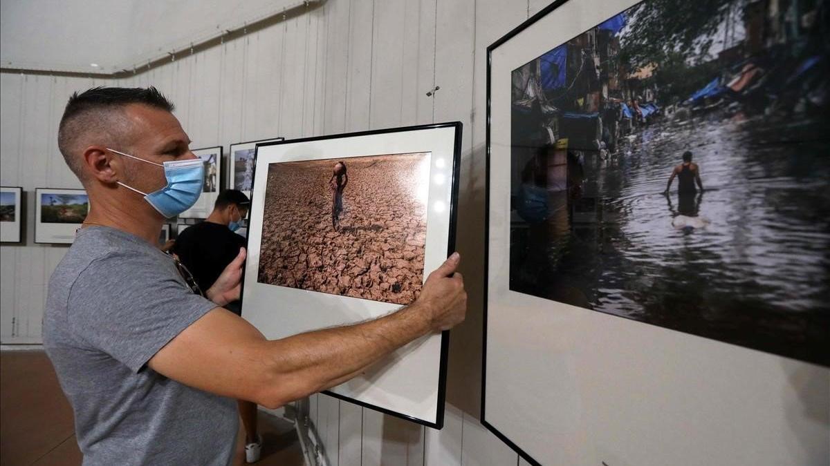 Un trabajador cuelga las fotos de la exposición Visa pour l'image en la localidad francesa de Perpiñán, el 25 de agosto del 2020