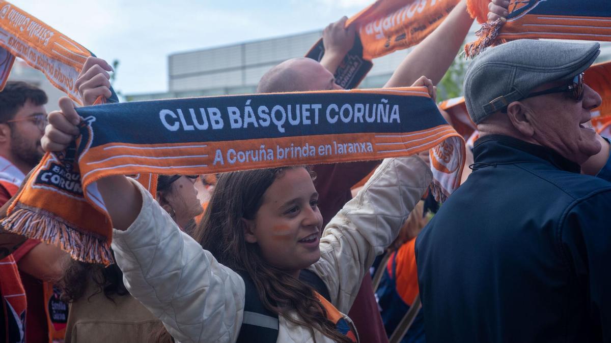 Una aficionada del Leyma alza su bufanda en un recibimiento a la plantilla naranja.