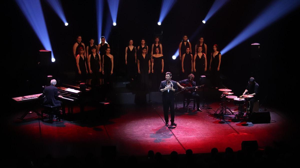 El cantaor, al centre de l’escenari, acompanyat del cor i dels músics durant el concert a l’Auditori de Girona.