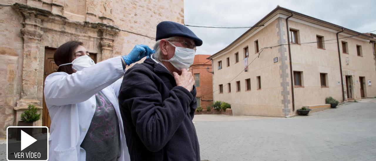 La doctora Silvia Soler coloca la mascarilla a Ángel, vecino de Vallanca de 86 años.