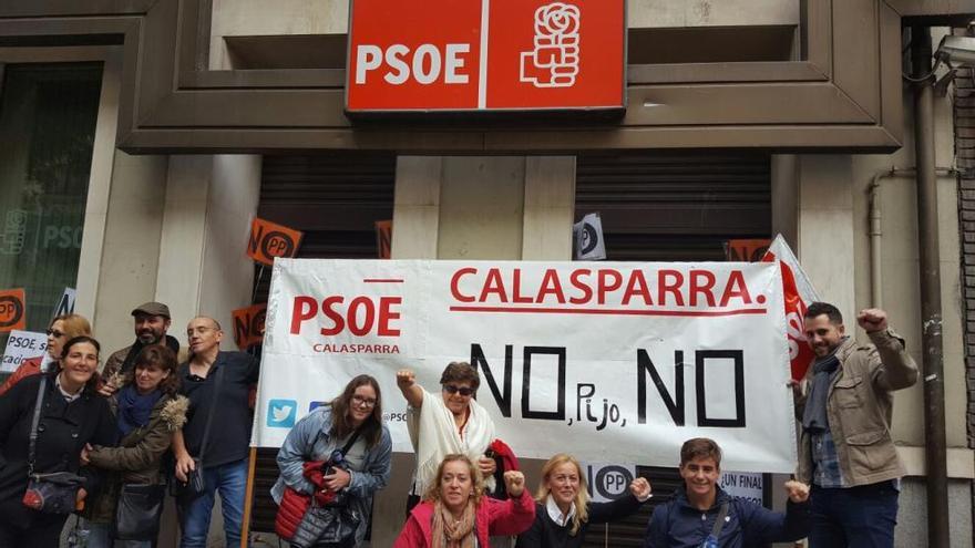 Simpatizantes socialistas de Calasparrra exhibieron este domingo una pancarta en la sede del PSOE, en la calle Ferraz de Madrid. A la derecha, Jordi Arce, teniente de alcalde de Calasparra.