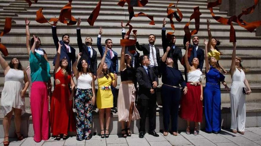 Los nuevos arquitectos técnicos, con su padrino, Ángel Guerra (centro), lanzan al aire sus becas de graduación.