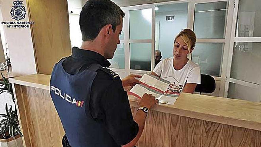 Un policÃ­a reparte el folleto con los consejos en un hotel de Palma.