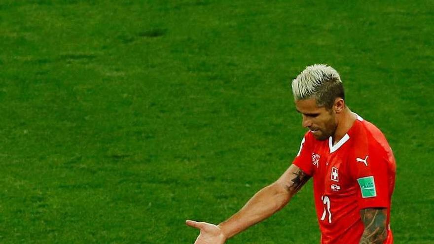 Neymar se duele en el suelo ante el suizo Behrami. // Reuters