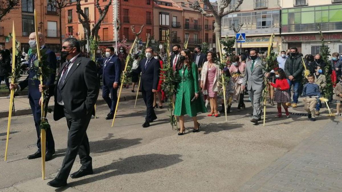 Autoridades y vecinos portan palmas y ramas en el desfile. | M. J. C.