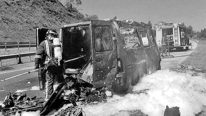 Bomberos extinguiendo el incendio en una autocaravana cerca del tunel de Tezangos, Ribadesella.