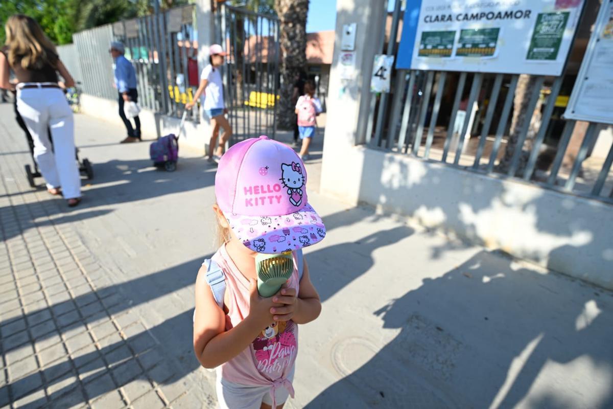 Una niña se da aire con su ventilador a baterías en el colegio Clara Campoamor de Elche