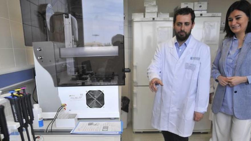 Uno de los investigadores del Hospital General muestra a la consellera de Sanidad, Carmen Montón, el nuevo test que mejora los tiempos de diagnóstico.