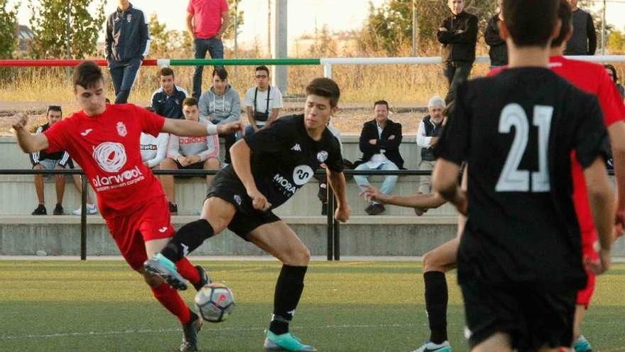 Un jugador de cada equipo lucha por hacerse con el control del balón.