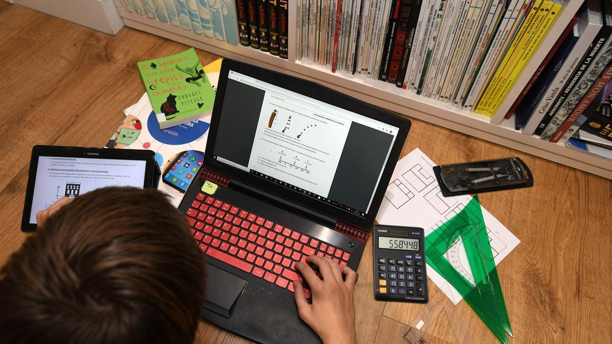 Un joven estudia con su ordenador en casa