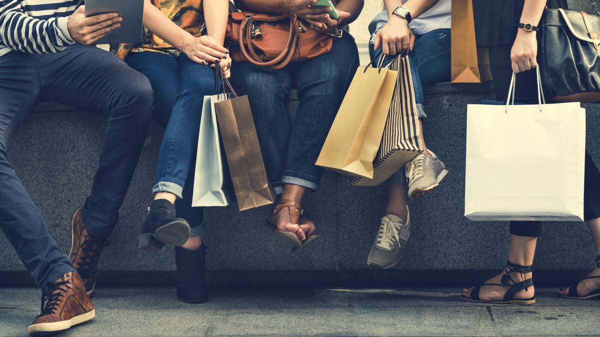 Un grupo de amigos descansa con sus bolsas de compras del Black Friday.