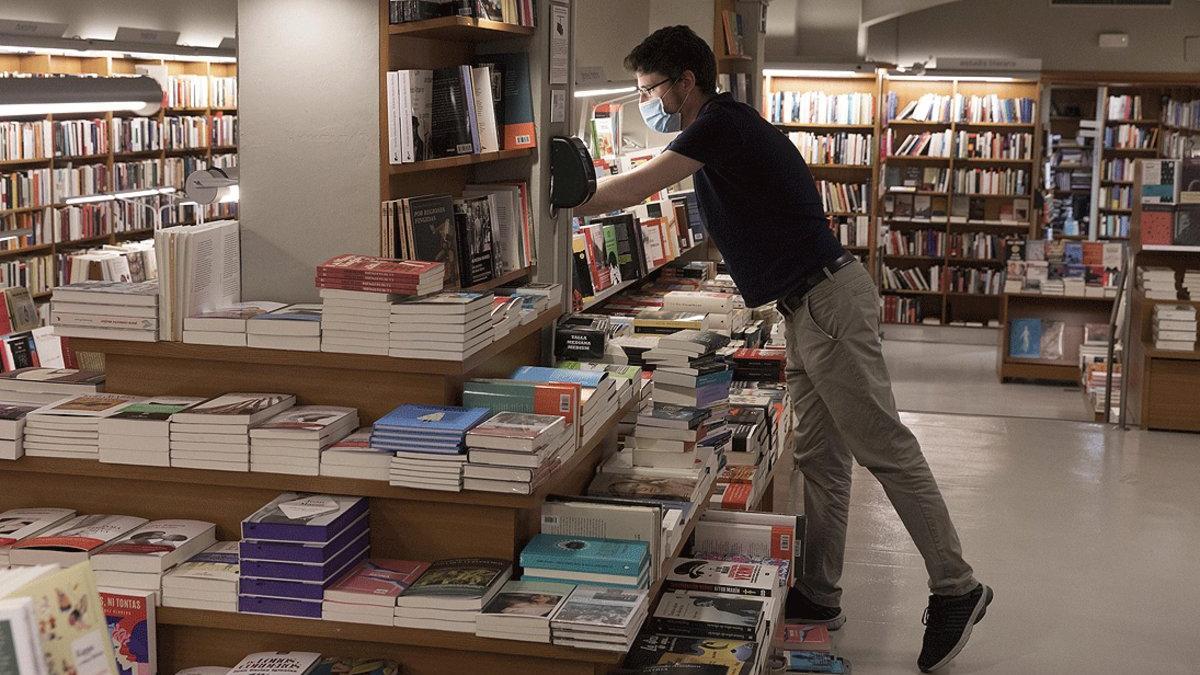 Un trabajador de Laie prepara la librería de la calle de Pau Claris de Barcelona para la reapertura parcial que se inicia el 4 de abril, este miércoles