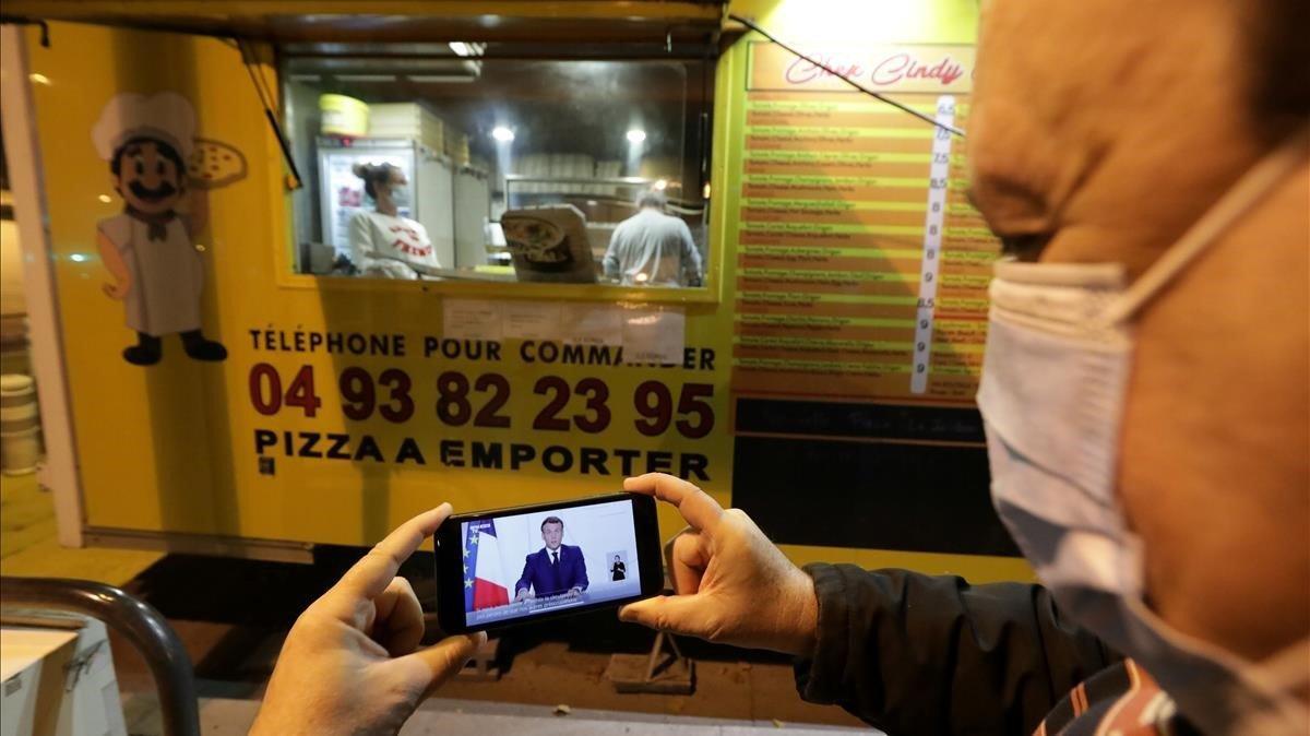 zentauroepp55974375 a man watches french president emmanuel macron on his mobile201124210659