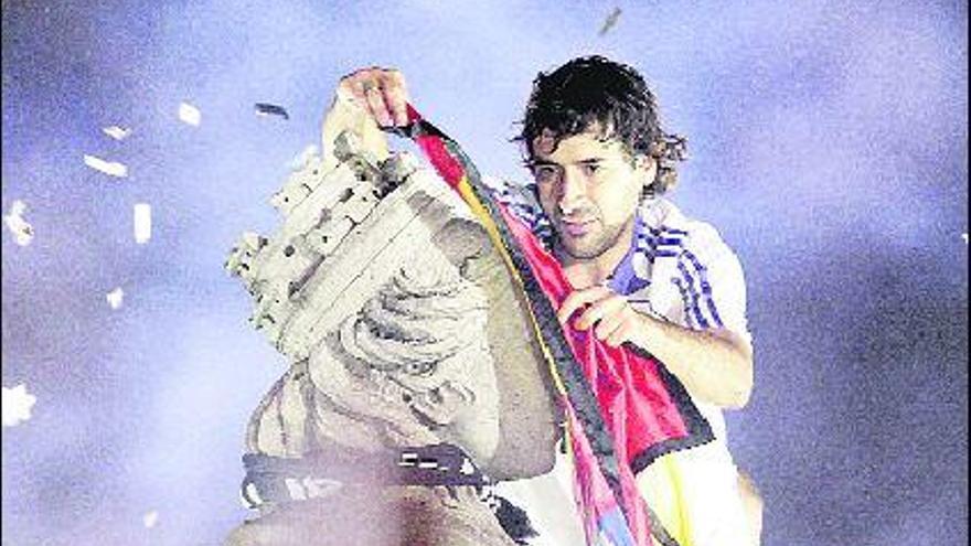 Raúl coloca una bandera de España con el escudo del Real Madrid a la diosa Cibeles.