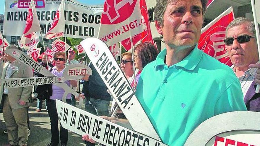 Un funcionario, ayer, con una simbólica tijera, durante la concentración sindical organizada ante la Delegación del Gobierno, en Oviedo.