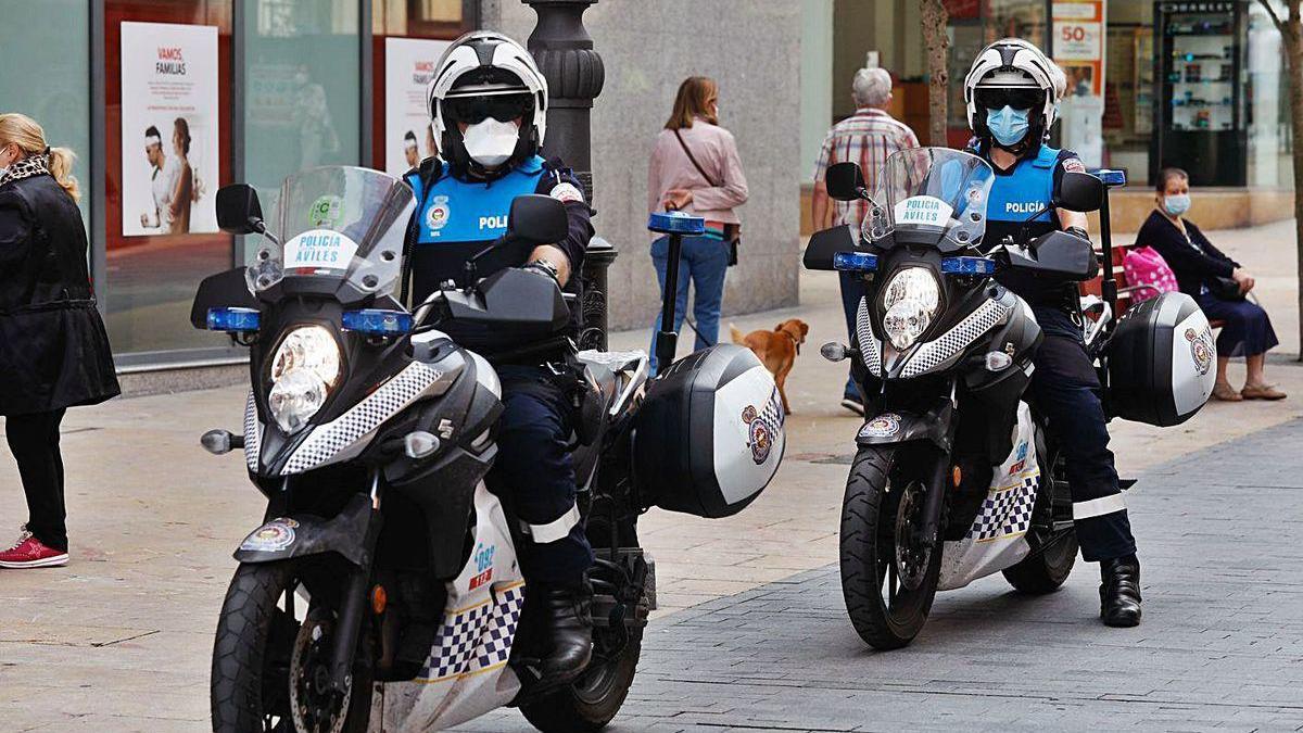 Una pareja motorizada de la Policía Local de Avilés patrulla la calle la Cámara.