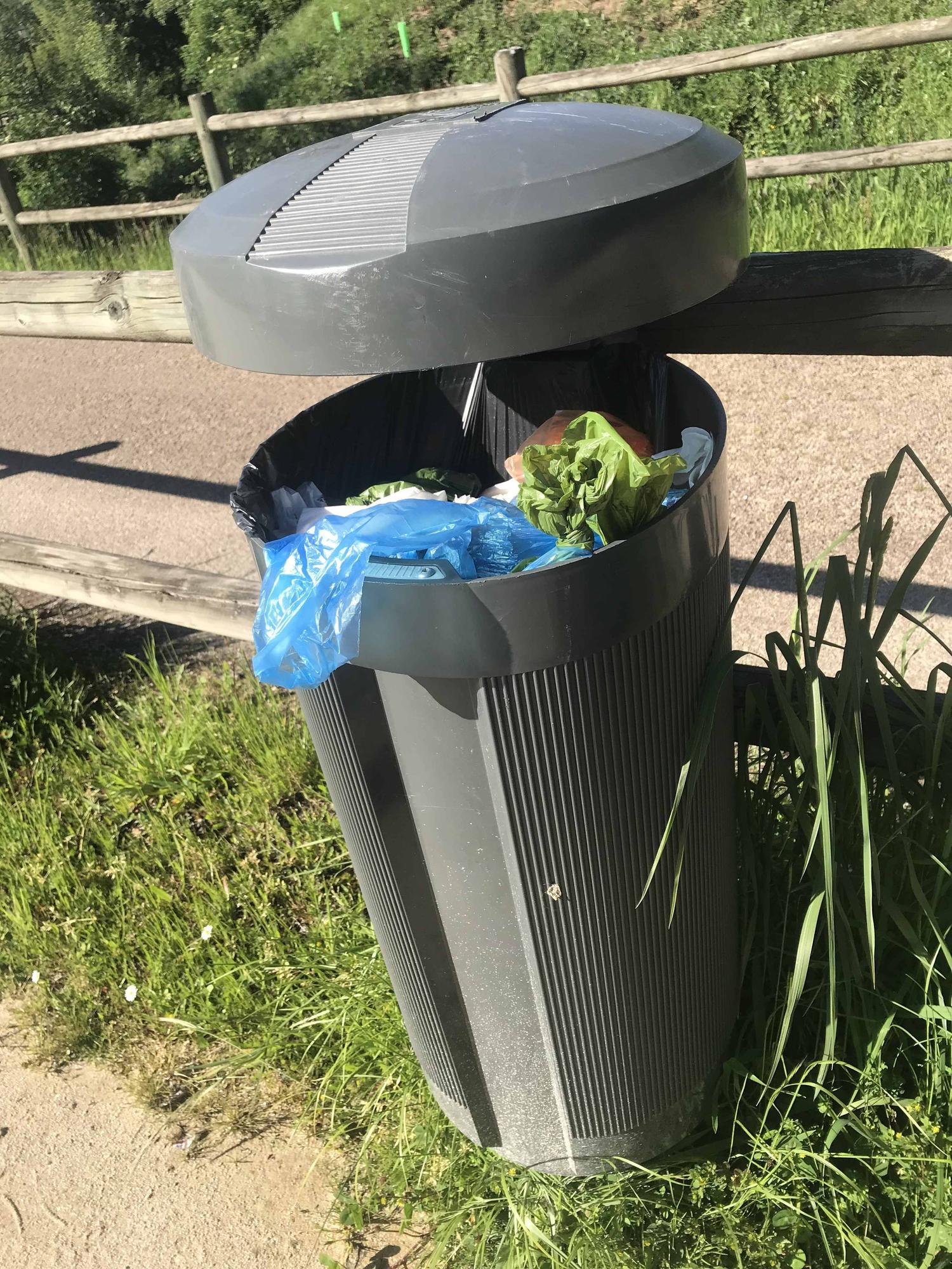 Una de las papeleras del paseo fluvial, llena de basura.