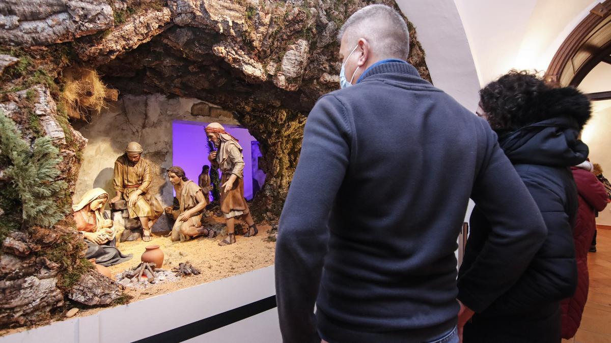 Turistas visitan este martes la muestra de belenes del mundo que expone el Palacio de los Golfines de Abajo.