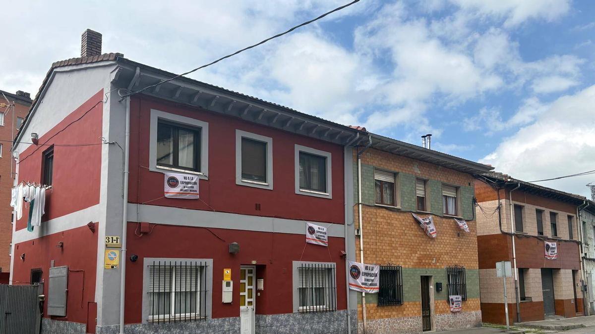 Casa del barrio de El Puente, en Langreo, con pancartas contra las expropiaciones