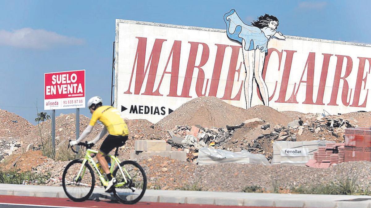 Un ciclista pasa frente a una valla publicitaria de Marie Claire en Castelló.