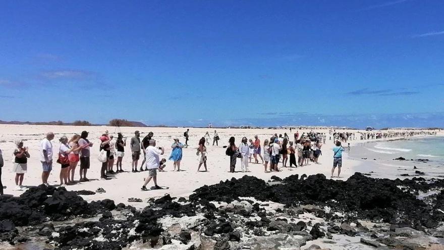 Imagen de la cadena humana formada ayer en la zona de grandes playas de Corralejo, en señal de rechazo a las prospecciones de tierras raras, ayer.