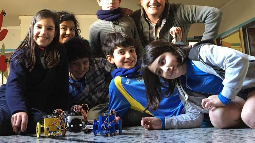 Arriba, por la izquierda, Sofía Prieto, Alejandra Blanco, Martín Adriano Barrera, Jorge Oliver, Lucas Rodríguez, Luis Toyos y Teresa Yuste, con varios robots, en el colegio Reconquista. A la izquierda, Alejandra Blanco y Sofía Prieto tocan el piano usando plátanos como teclas.