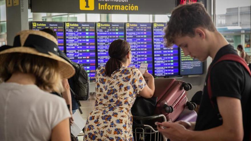 Varias personas esperan en el aeropuerto de El Prat.