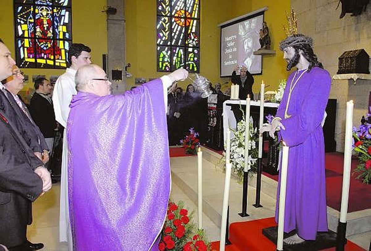 El párroco de San Javier de la Tenderina bendice la imagen del Señor de la Sentencia.