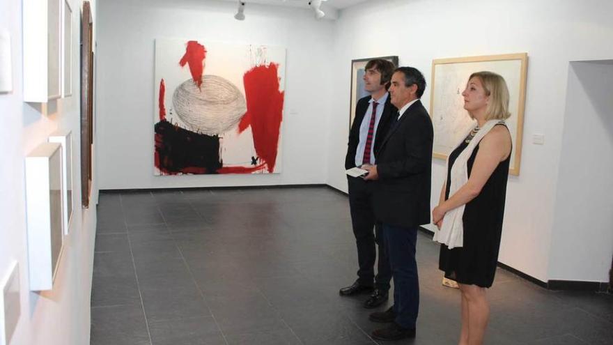 El director del Bellas Artes, Alfonso Palacio, a la izquierda, muestra la exposición al viceconsejero de Cultura, Vicente Domínguez, y a la concejala de Cultura de El Franco, Victoria Zarcero.