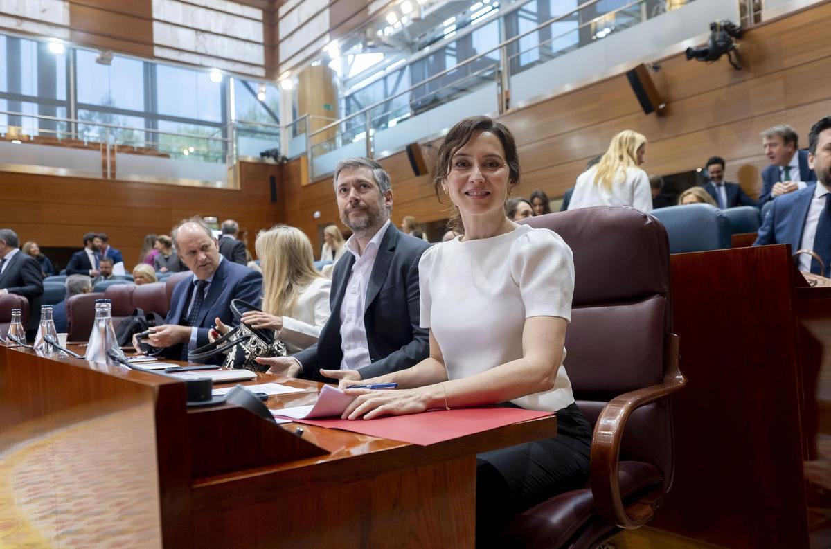 La presidenta de la Comunidad de Madrid, Isabel Díaz Ayuso (d), y el consejero de Presidencia, Justicia y Administración Local, y portavoz del Gobierno autonómico, Miguel Ángel García Martín (I), durante el Pleno de la Asamblea de Madrid