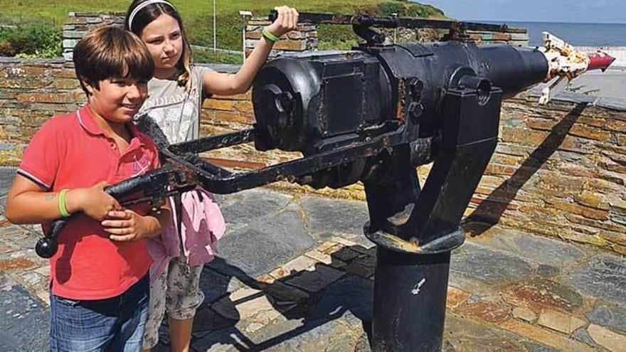 Aday y Violeta Martín, con el cañón empleado para pescar ballenas, durante la visita a Puerto de Vega.